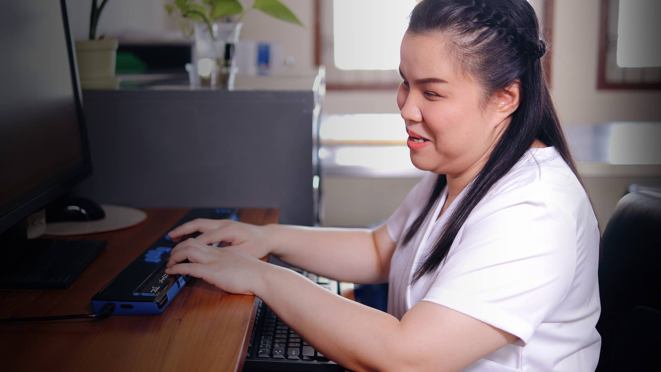 mulher digitando em um teclado braille